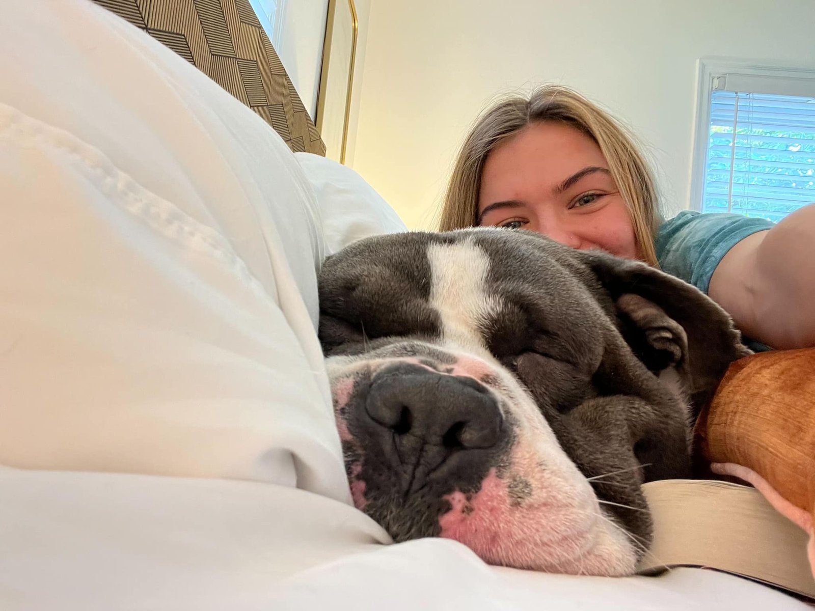 woman laying next to a sleeping dog